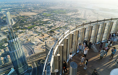 Tourists meet the sunrise on the observation deck of the Burj Khalifa tower. © TOXAWWW | DREAMSTIME